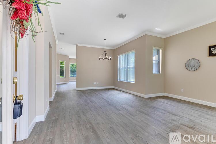A spacious room with wooden flooring and a hanging light fixture.