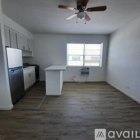 A kitchen with white cabinets and a white fridge.