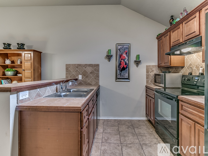 A kitchen with wooden cabinets and a tiled backsplash.