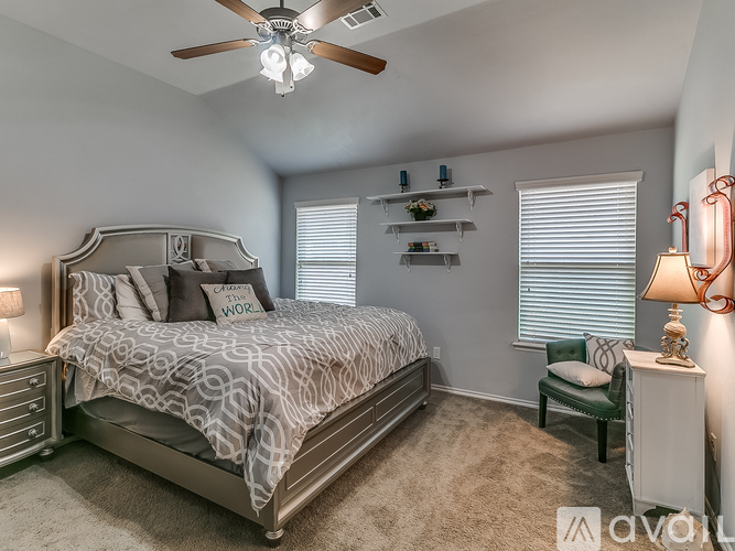 A bedroom with a large bed and a ceiling fan.