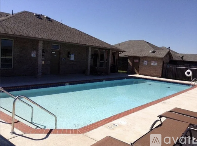 A swimming pool in front of a building with a clear blue sky.