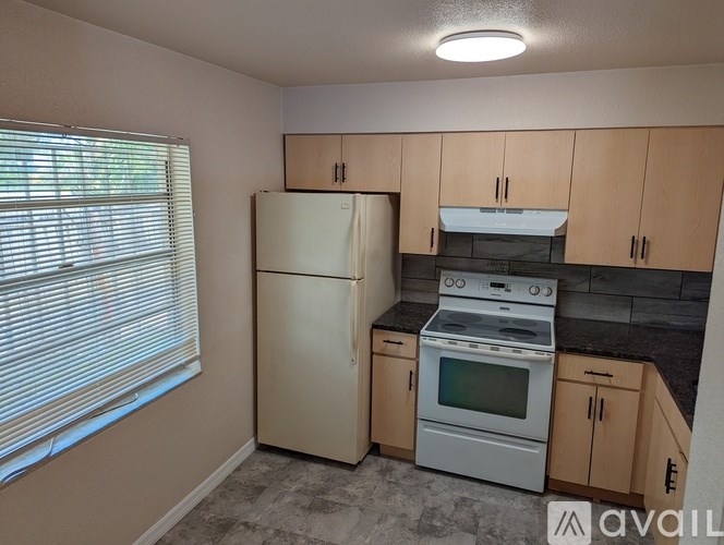 A kitchen with a refrigerator, oven, and cabinets.