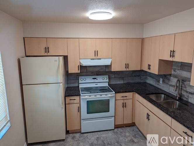 A kitchen with a white refrigerator, stove, and oven.