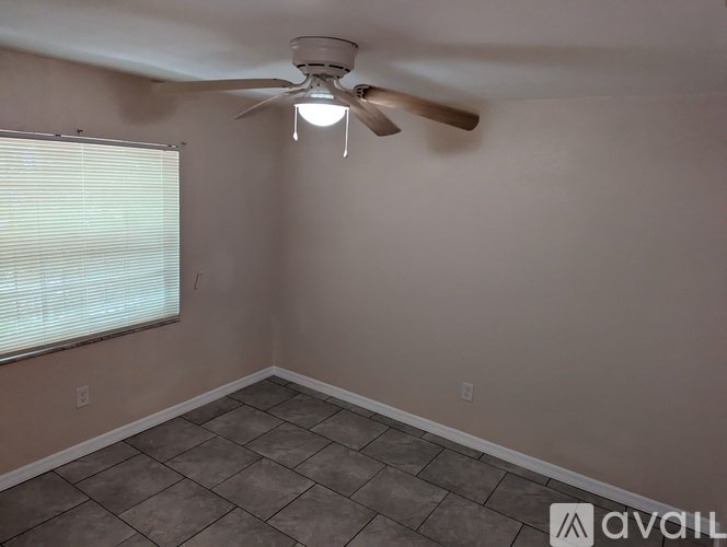 A room with a ceiling fan and tiled floor.