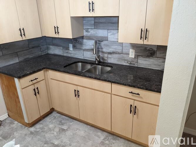 A kitchen with wooden cabinets and a black countertop.