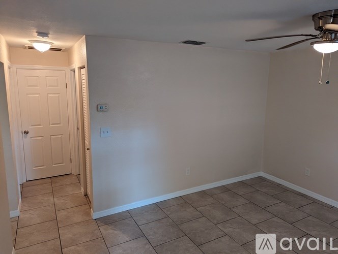 A room with a door and a ceiling fan.