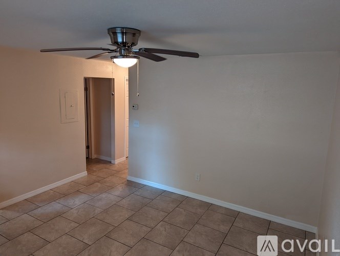 A room with a ceiling fan and tiled floor.
