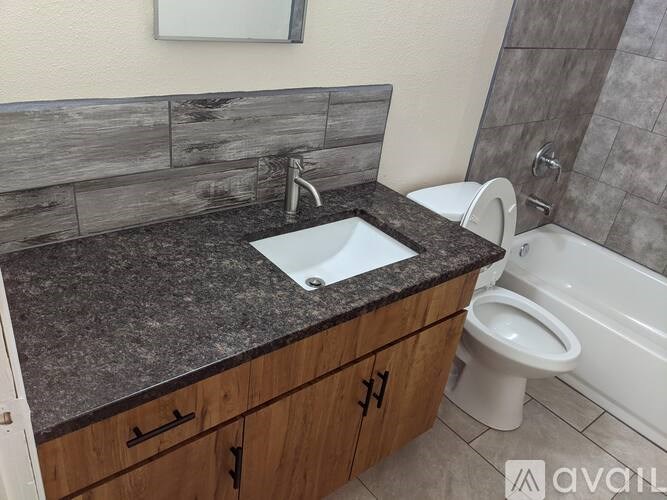 A bathroom with a sink, toilet, and bathtub.