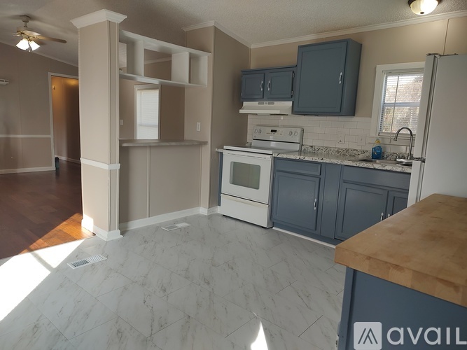 A kitchen with a marble floor and a wooden counter top.