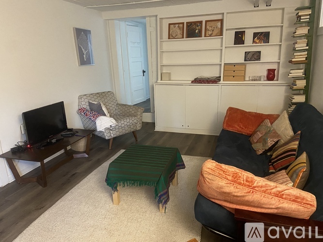 A living room with a couch, chair, and a television.