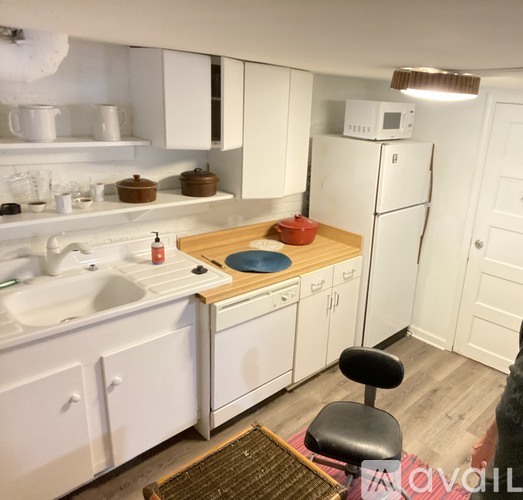 A kitchen with white cabinets and a white fridge.