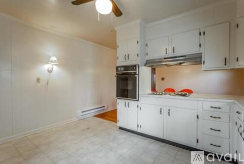 A kitchen with white cabinets and a black oven.