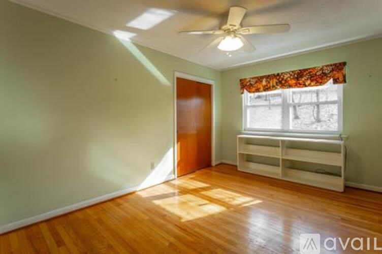 A room with a wooden floor and a ceiling fan.