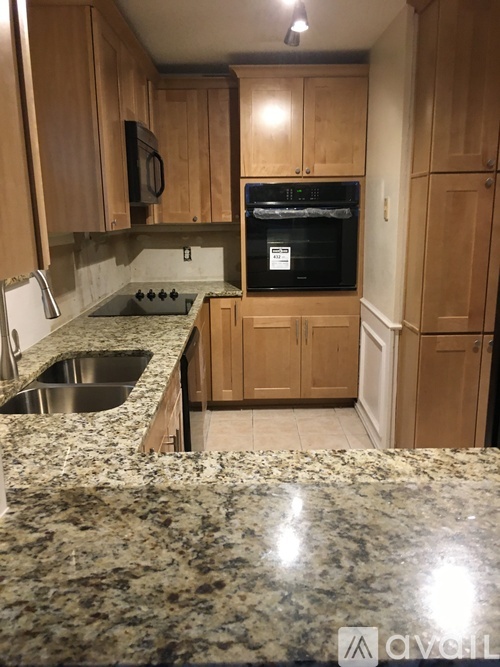 A kitchen with granite countertops and wooden cabinets.