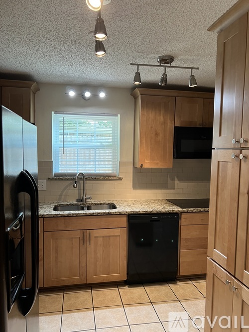 A kitchen with wooden cabinets and a black oven.