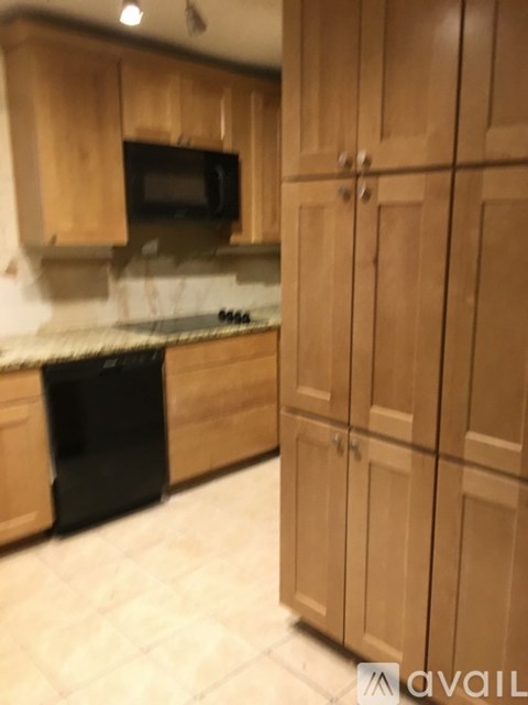 A kitchen with wooden cabinets and a black oven.
