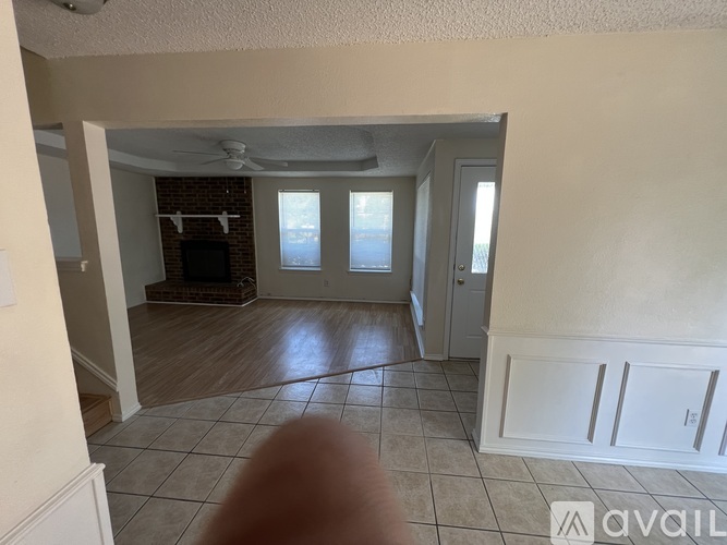 A living room with a fan and a door leading to another room.
