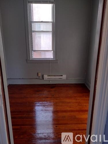 A room with a window and wooden floors.