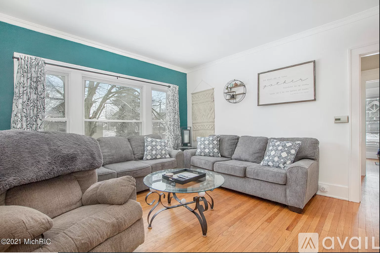 A living room with a grey couch and a glass coffee table.