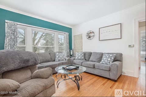 A living room with a grey couch and a glass coffee table.
