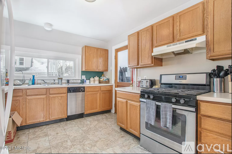A kitchen with wooden cabinets and a black stove top oven.