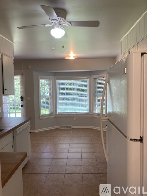 A kitchen with white cabinets and a white refrigerator.