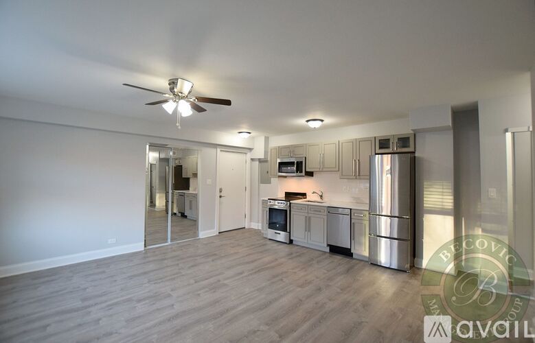 A spacious kitchen with stainless steel appliances and a ceiling fan.