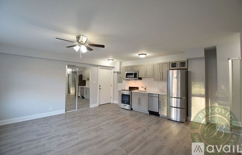A spacious kitchen with stainless steel appliances and a ceiling fan.