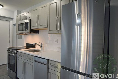 A modern kitchen with stainless steel appliances and a white countertop.
