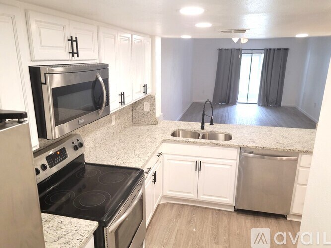 A kitchen with white cabinets and a black stove top oven.