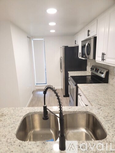 A kitchen with a sink and a refrigerator.