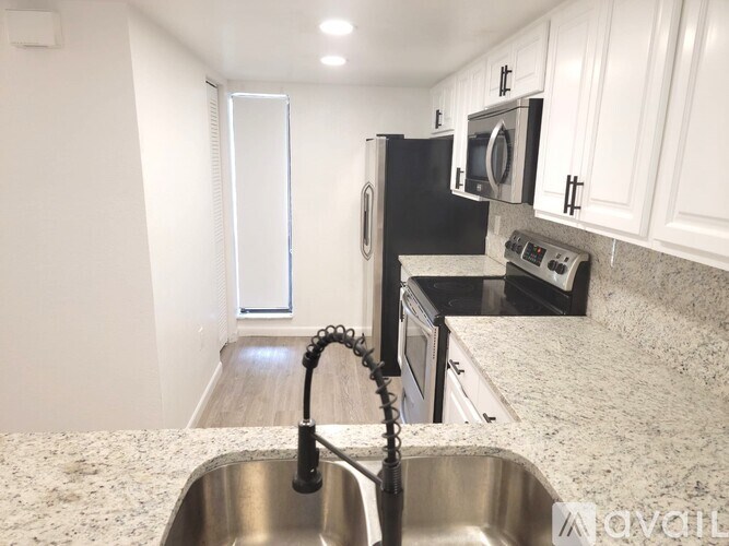 A kitchen with a sink and a refrigerator.