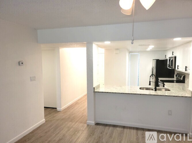 A kitchen area with a sink and a microwave.