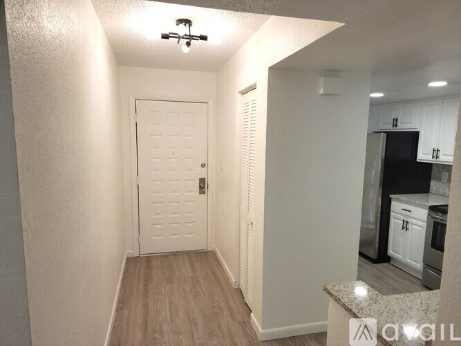 A white door with a black handle is in a room with white walls.