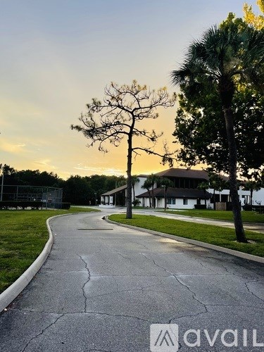 A street with a house and trees on the side.