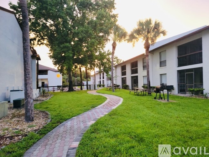 A brick pathway leads through a grassy area in front of a building.