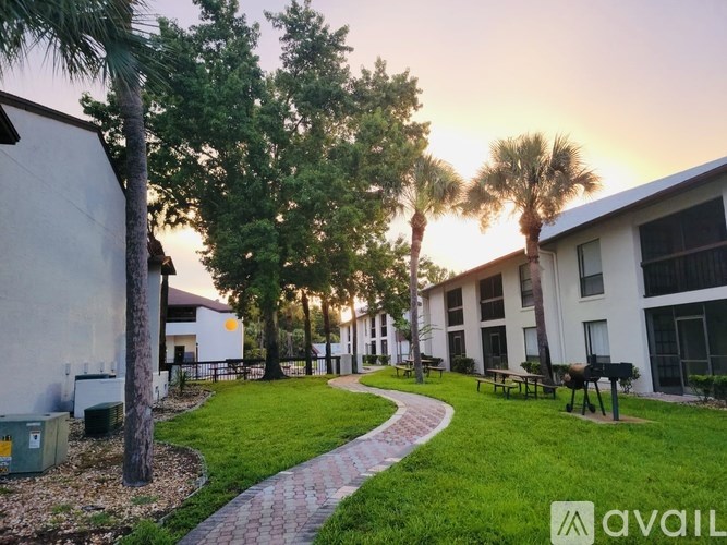 A sunset view of a residential area with apartment buildings and palm trees.