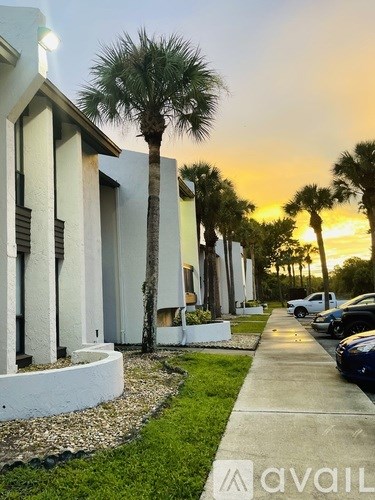 A row of houses with a palm tree in front of one.
