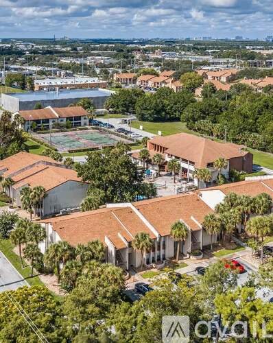 A bird's eye view of a residential area with houses and a tennis court.