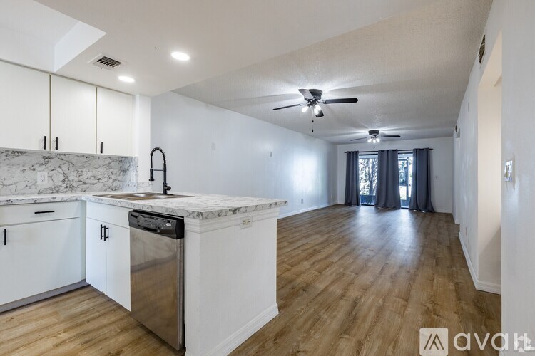 A kitchen with white cabinets and a marble countertop.