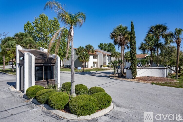 A sunny day in a residential area with a house and palm trees.