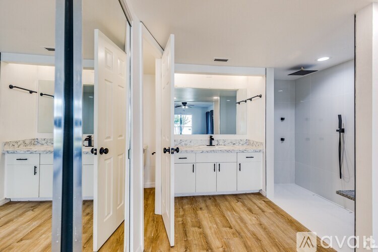 A modern bathroom with a double sink vanity and a walk-in shower.
