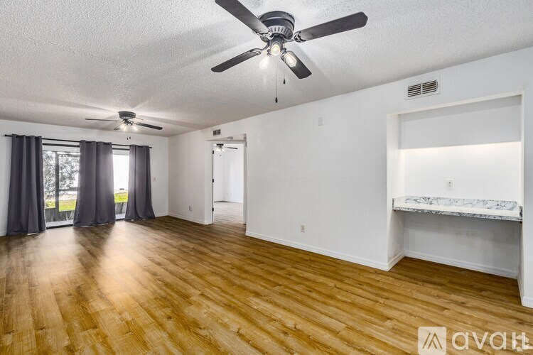 A room with wooden floors and a ceiling fan.