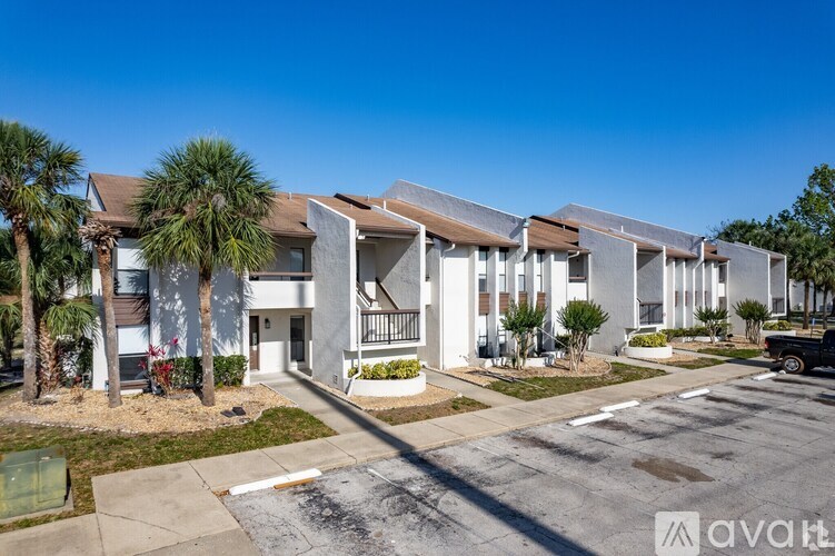 A row of modern townhouses with a clear blue sky above them.