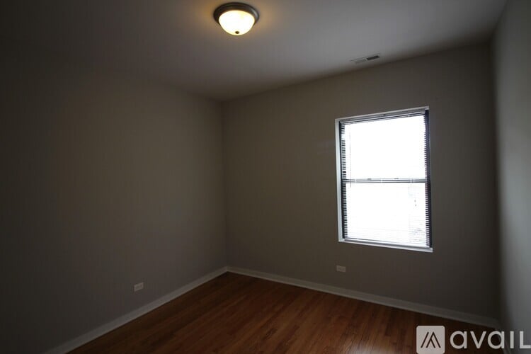 A room with a window and wooden flooring.