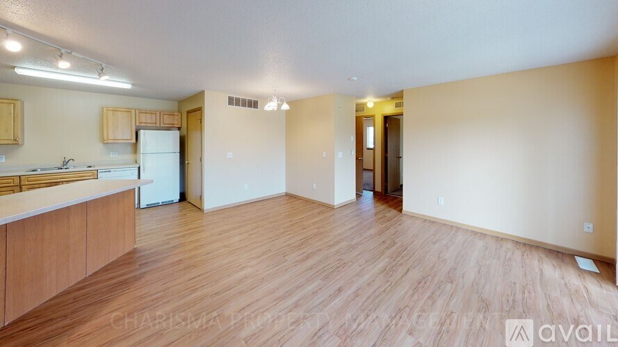 A kitchen with wooden floors and a white refrigerator.