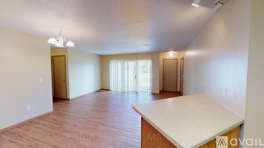 A spacious room with wooden floors and a large bed in the foreground.