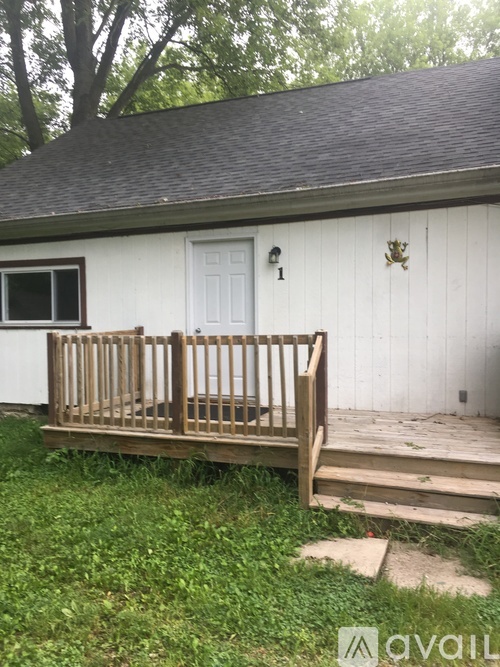 A white house with a wooden porch and a number 1 on the door.