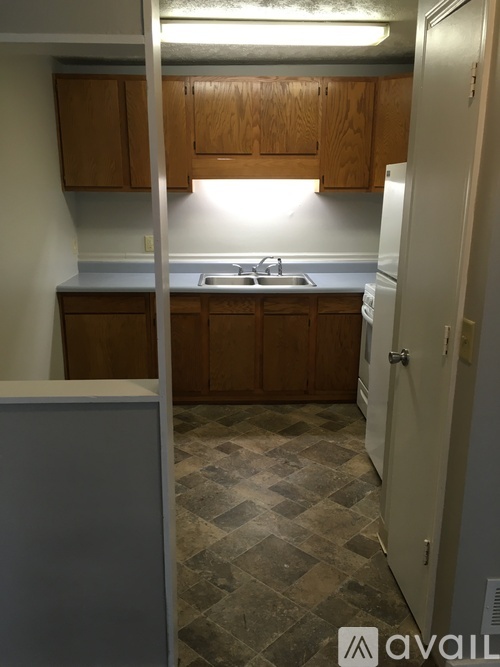 A kitchen with wooden cabinets and a checkered floor.