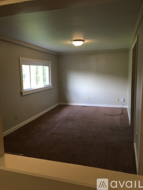 A room with a window and carpeted floor.
